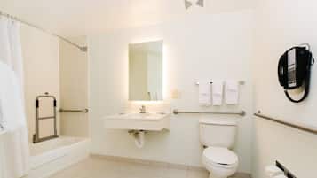 Een badkamer met een bad, wastafel, toilet en douche.