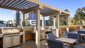 An outdoor patio with a grill station, seating area, and a view of the cityscape. - Candlewood Suites Anaheim - Resort Area by IHG (Anaheim)