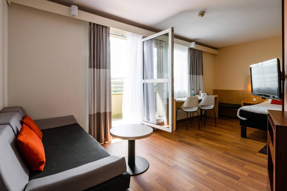 Suite junior, 1 cama doble con sofá cama, balcón | Escritorio, tabla de planchar con plancha, wifi gratis y ropa de cama