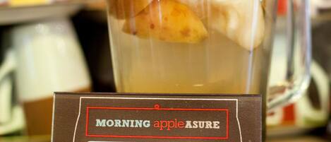 A glass pitcher with a label reading "MORNING apple ASURE" and "APPLE COMPOTE FROM GRANDMA'S RECIPE".