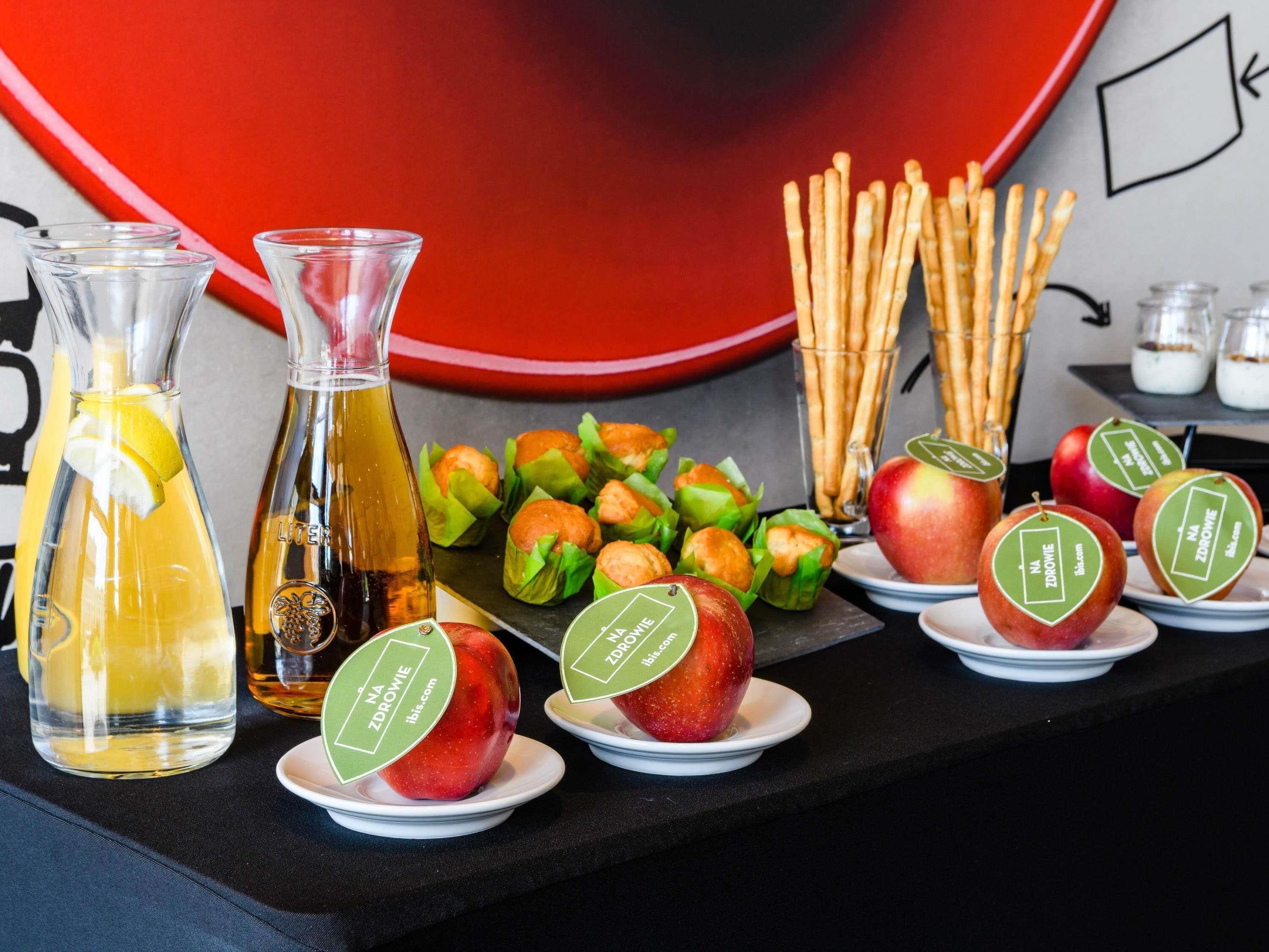 A table with food items, including apples and pastries, and two bottles of beverages.
