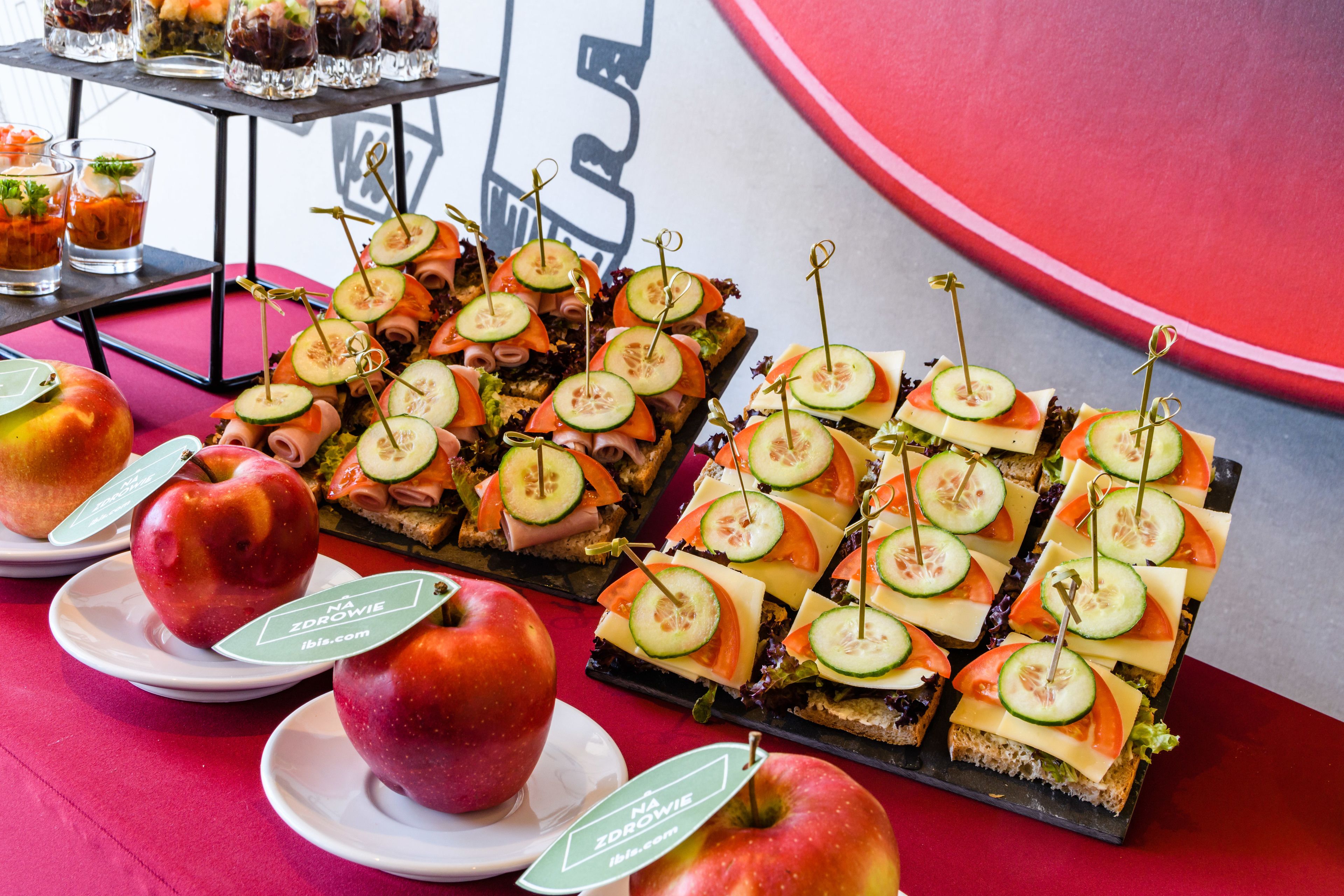 Una mesa con diferentes alimentos, como sándwiches, manzanas y bebidas.