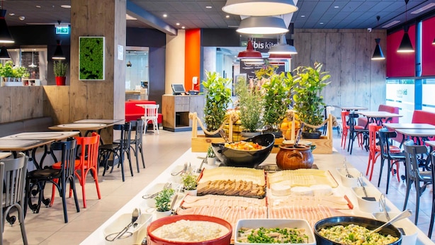 Een eetgedeelte in buffetstijl met diverse gerechtjes, waaronder een rode schaal met cottage cheese, een groene schaal met salade en een zwarte schaal met soep.