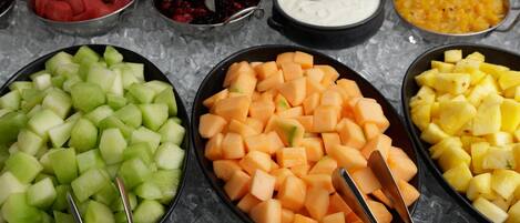Un buffet proposant une variété de fruits et de sauces pour tremper.