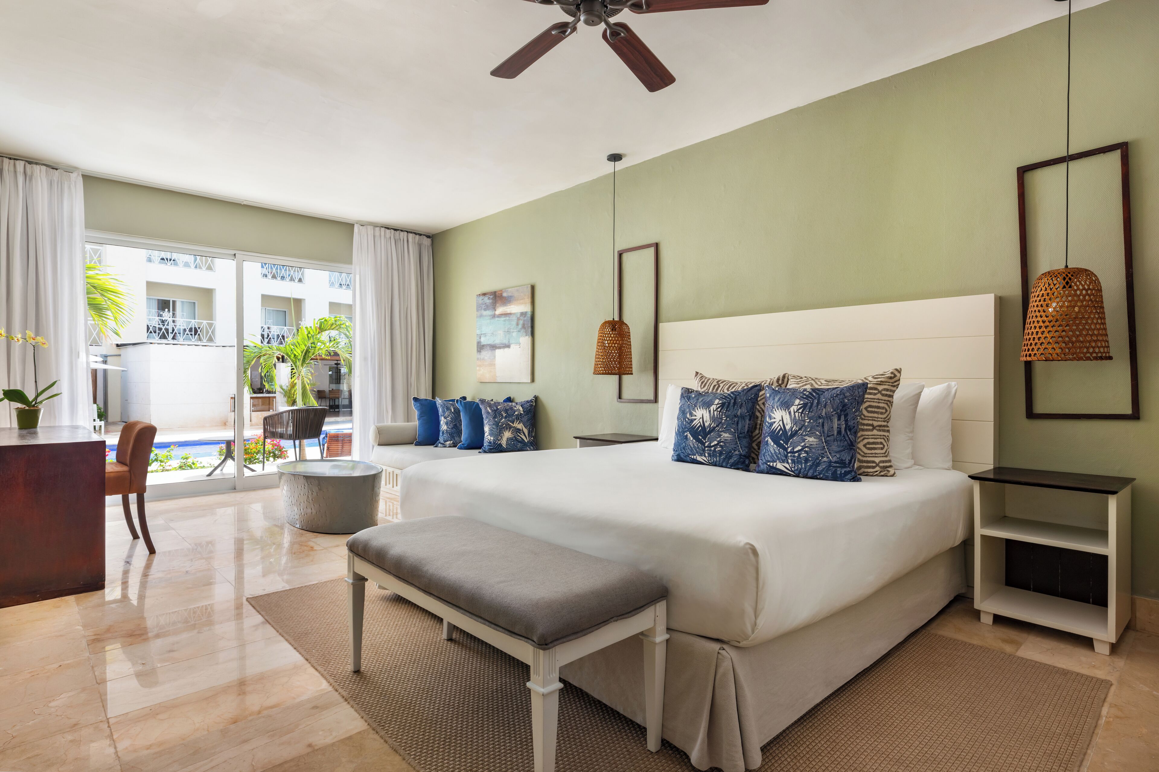 A bedroom with a large bed, a desk, and a chair.