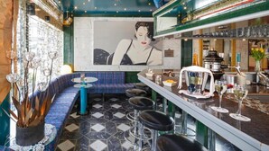 A bar area with a patterned floor, a blue sofa, bar stools, and a large abstract painting on the wall. - Hotel Luzernerhof (Lucerne)