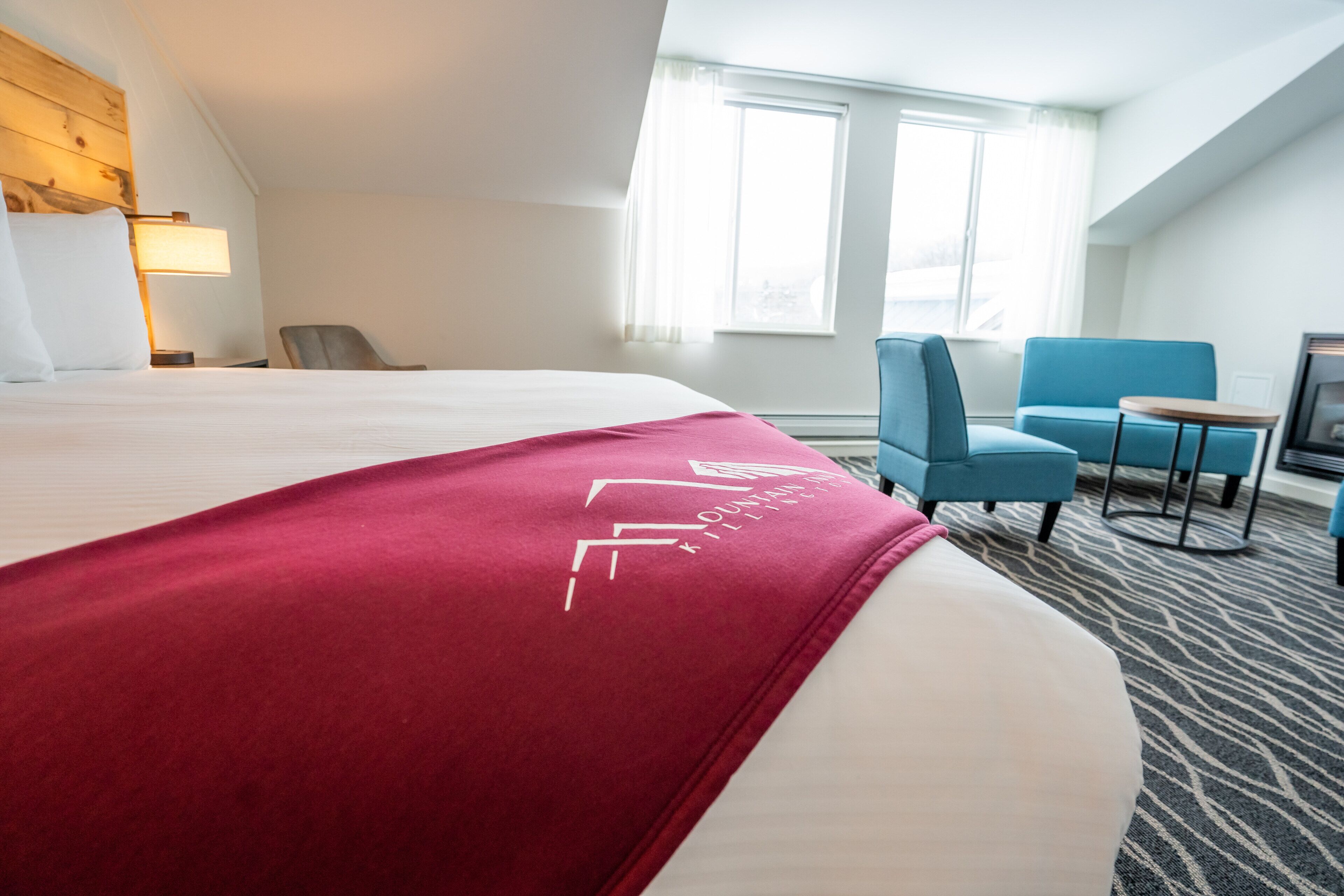 Een hotelkamer met een groot bed, een bureau, een stoel en een televisie.