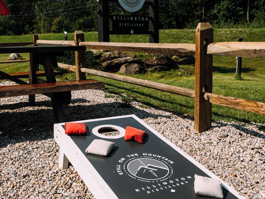 A distillery sign with a logo and the name "Kellington Distillery" on a wooden board.