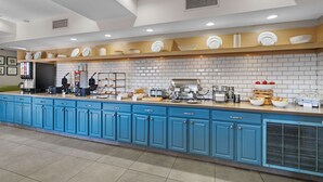 A modern kitchen with blue cabinets, white tiled backsplash, and various appliances. - Country Inn & Suites by Radisson, Myrtle Beach, SC (Myrtle Beach)