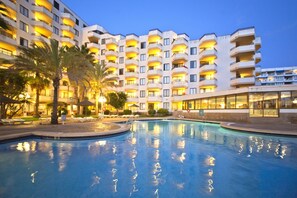 A hotel with a pool, multiple balconies, and palm trees. - TRH Jardin Del Mar (Calvia)