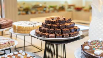 A dessert display with various cakes and brownies.