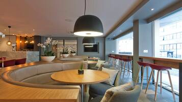 A modern interior with a curved seating area, a bar counter, and large windows providing a view of the outside.