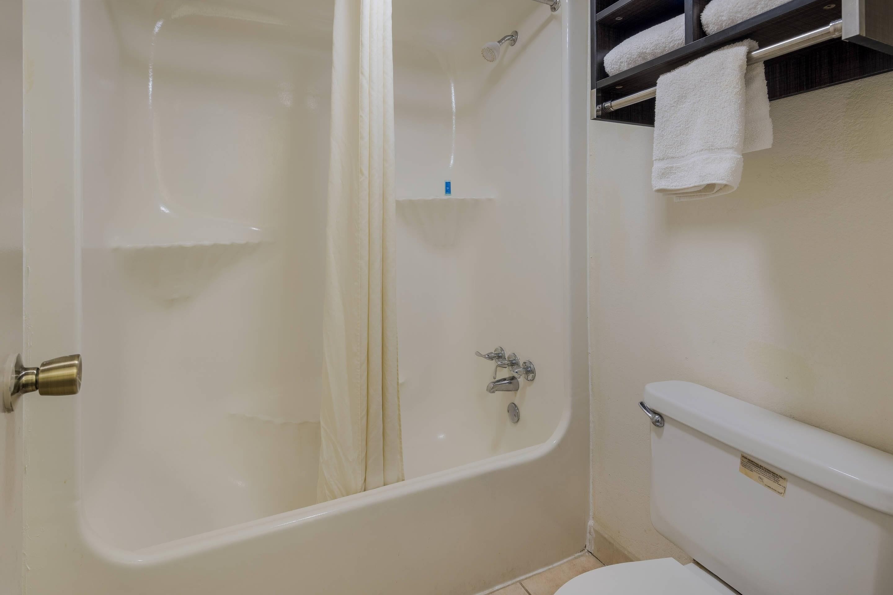 Ein Badezimmer mit Badewanne, Toilette und Handtuchhalter.