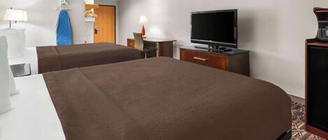 Habitación de hotel con dos camas, televisión, escritorio con lámpara y armario.
