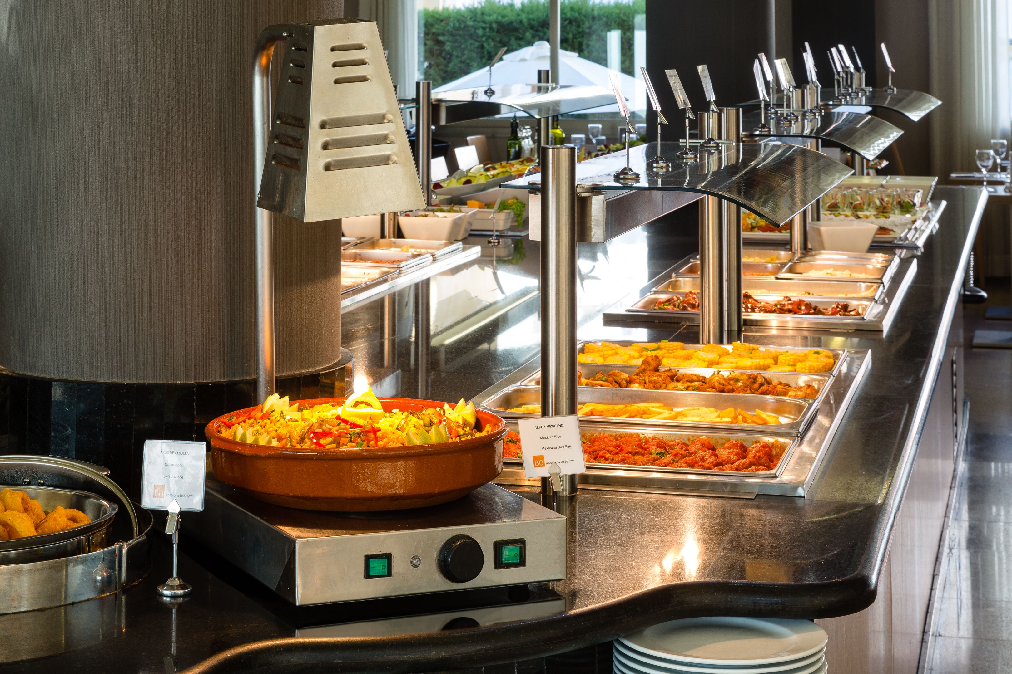 A buffet with various food stations, including a large pot of chili and multiple trays of different dishes.