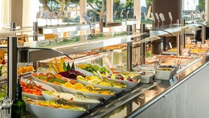 Un bufé con diversas opciones de comida, incluyendo frutas, verduras y ensaladas.