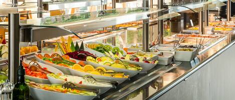 A buffet with various food options including fruits, vegetables, and salads.