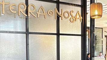 Uma placa com a inscrição 'TERRA ONOSA' em fonte de madeira, indicando o nome do local.