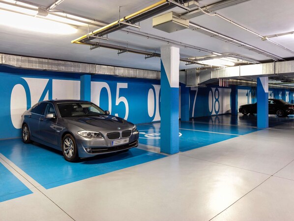 Un garaje para estacionar con un BMW aparcado en un espacio señalado con números grandes.