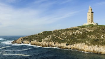 Un faro en una colina rocosa con vista al mar.