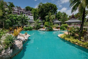 Una piscina al aire libre, sombrillas, tumbonas