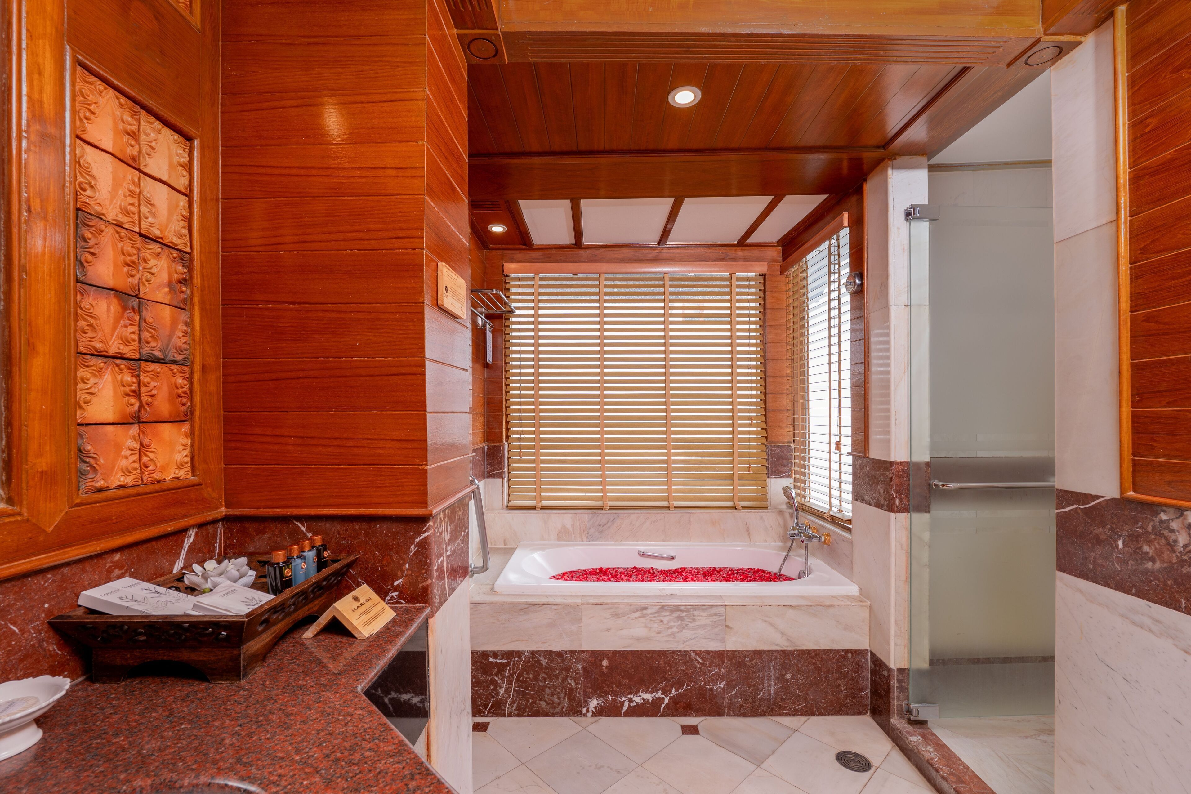 A bathroom with a bathtub, shower, and wooden paneling.
