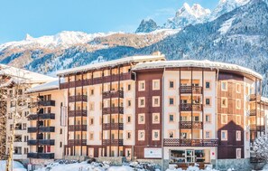 A multi-story hotel with balconies, set against a snowy mountain backdrop. - Résidence Pierre & Vacances Chamonix La Rivière (Chamonix-Mont-Blanc)