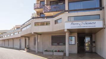 A multi-story hotel with a sign reading "Pierre & Vacances" and balconies with outdoor furniture.