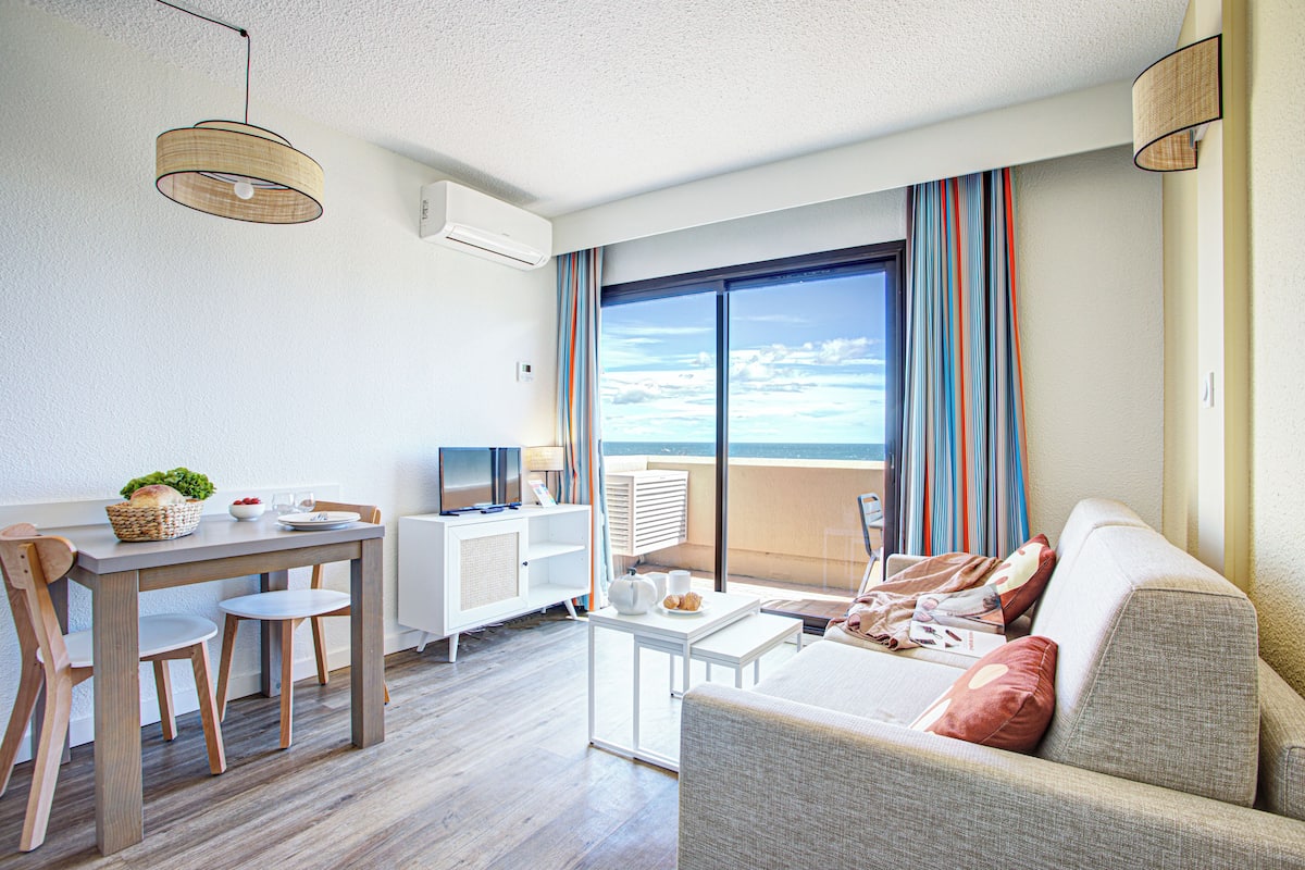 En moderne stue med balkon, spiseplads og sofa.