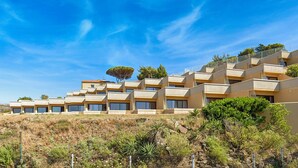 A multi-story hotel with a flat roof terrace, surrounded by natural vegetation and a clear blue sky. - Pierre & Vacances Résidence Les Balcons de Collioure (Collioure)