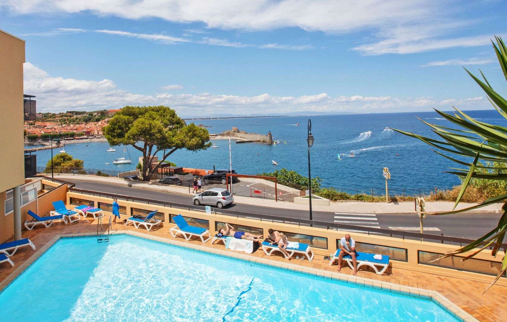 Un espace piscine avec des chaises longues et vue sur la mer.
