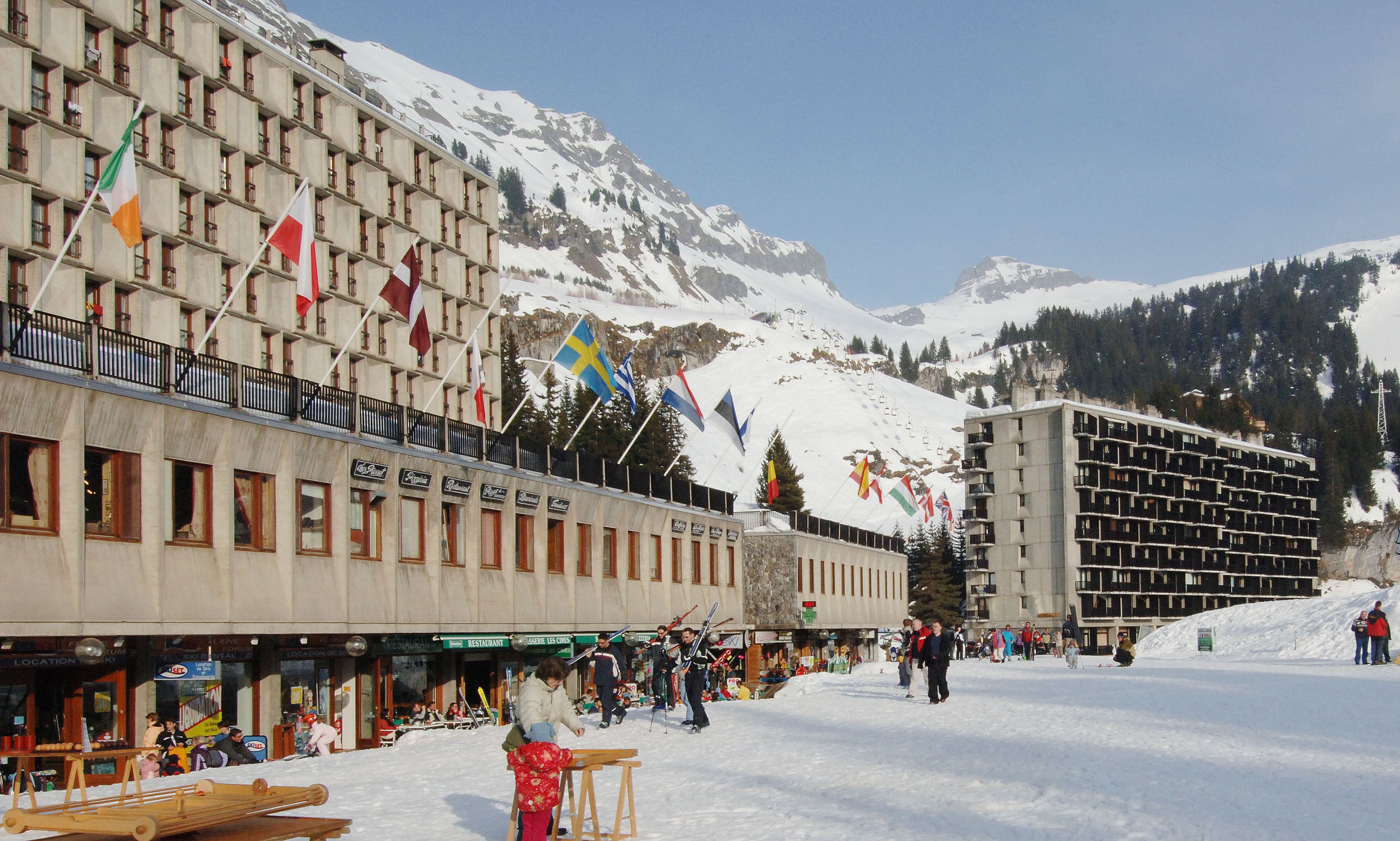 A hotel with multiple floors, balconies, and flags.