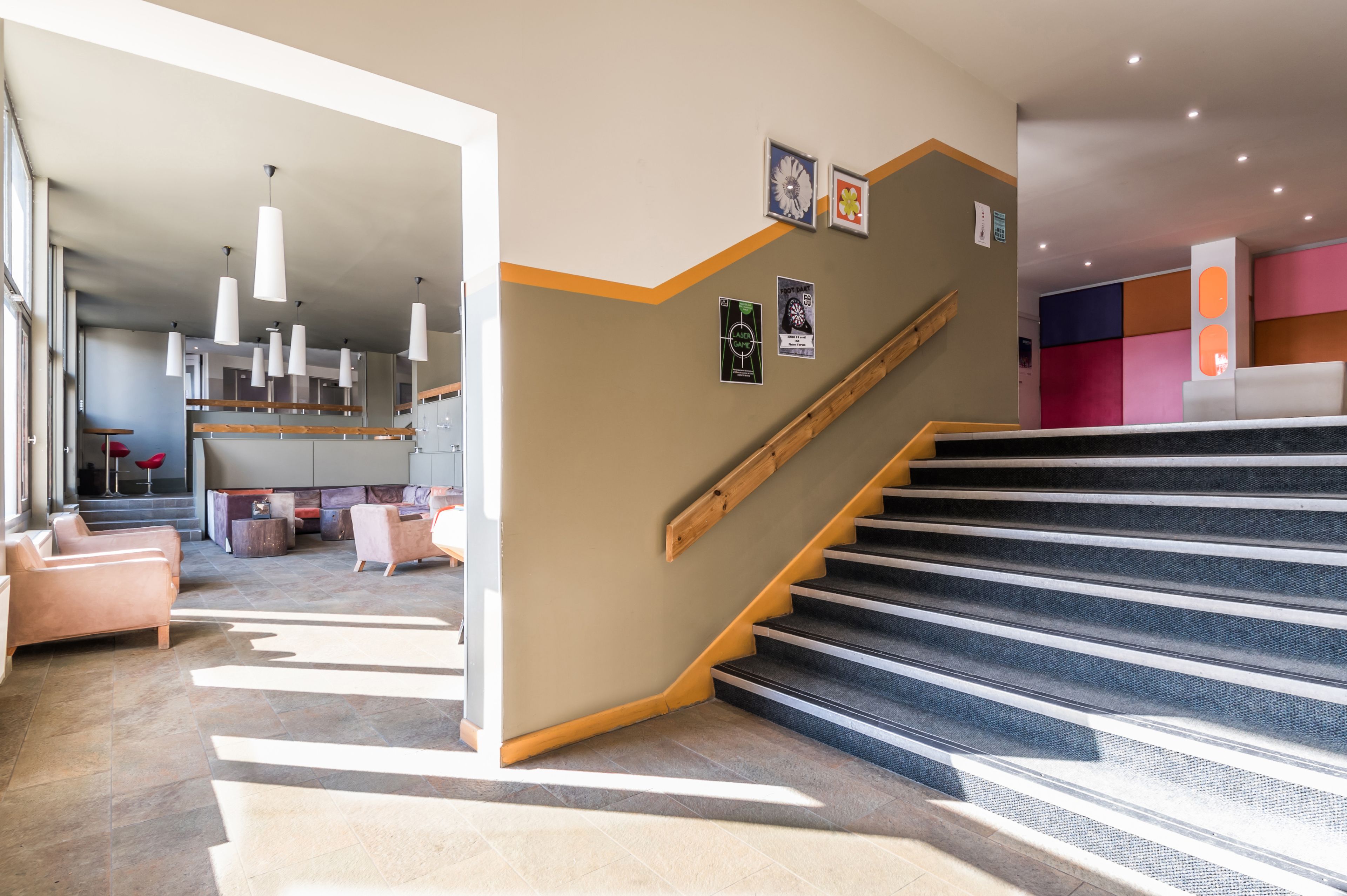 A modern interior with a staircase, a reception area, and a seating area with sofas and a coffee table.