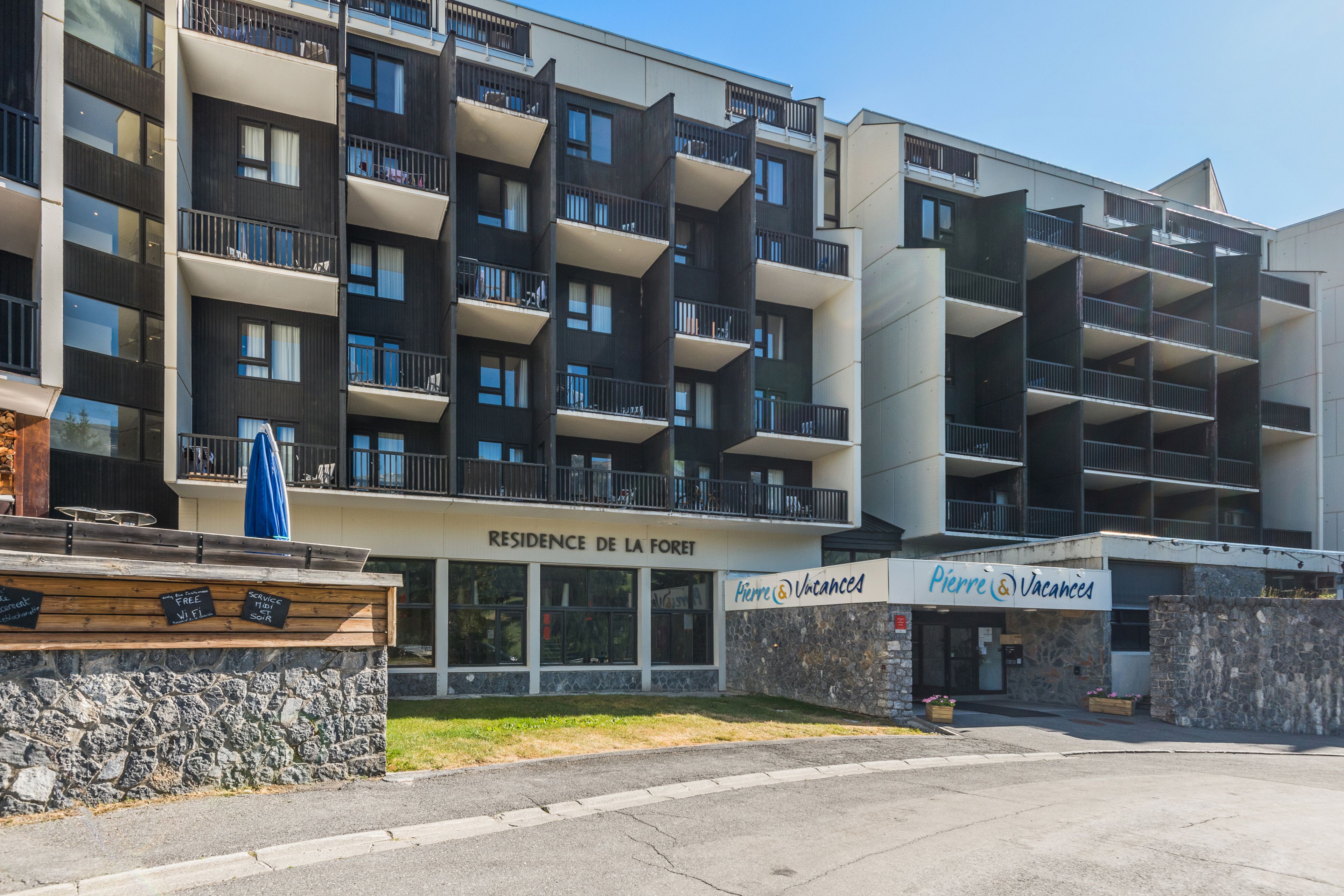 A multi-story hotel with balconies, a stone facade, and a sign for 'Pierre & Vacances'.