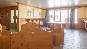 A room with wooden furniture, a pool table, and large windows. - Résidence Pierre & Vacances Les Valmonts (Les Belleville)
