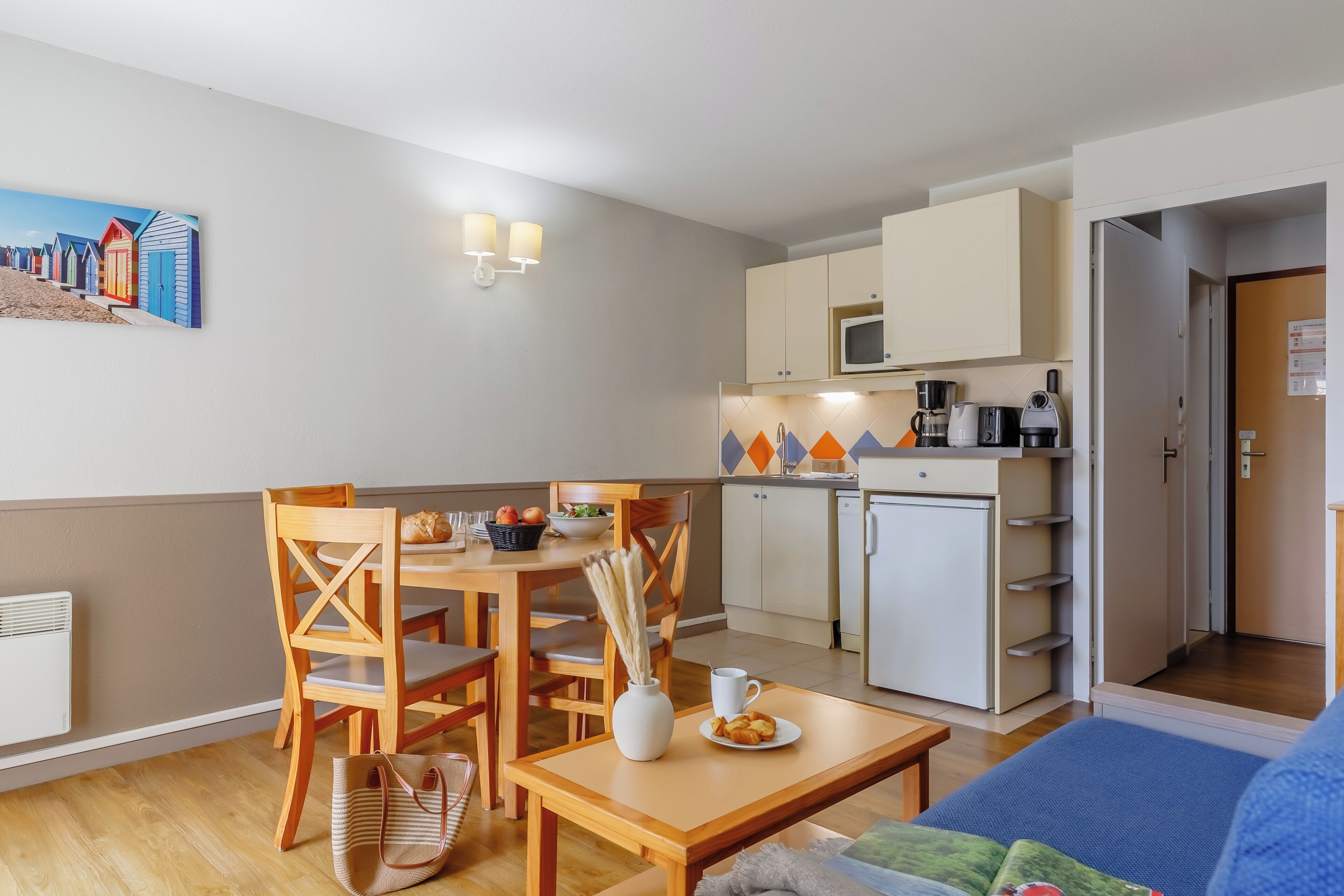 Um espaço compacto com área de refeições, cozinha compacta e uma cama.
