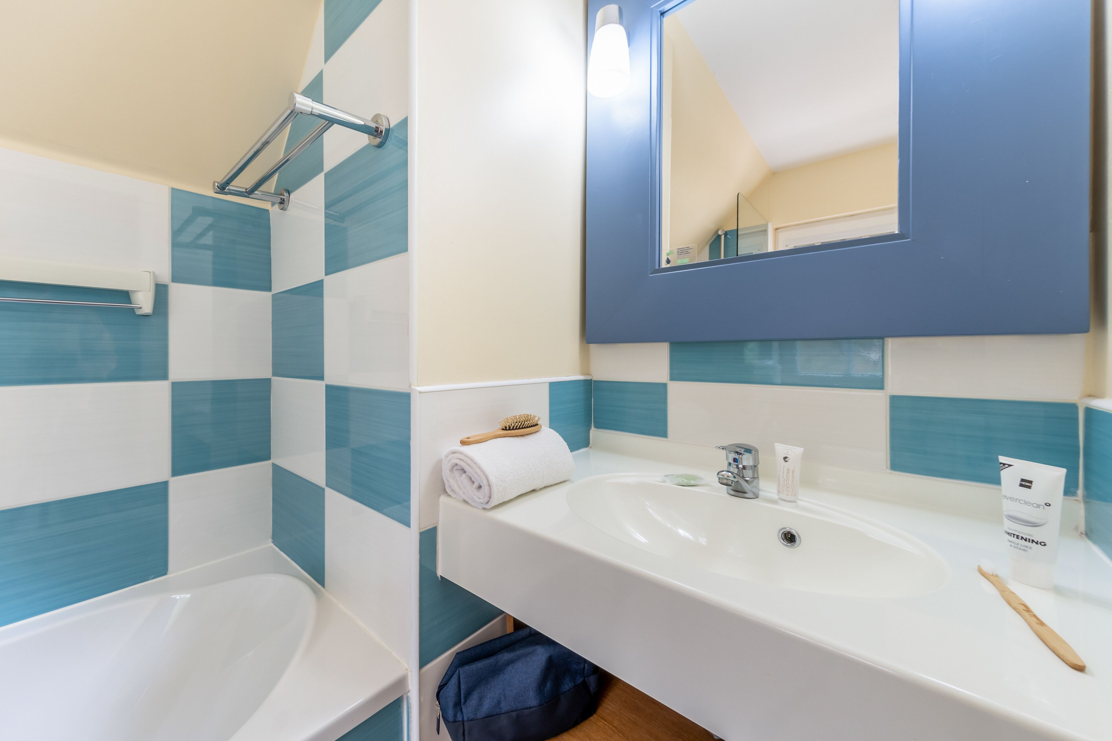 A bathroom with a white sink, a mirror, and a shower area.