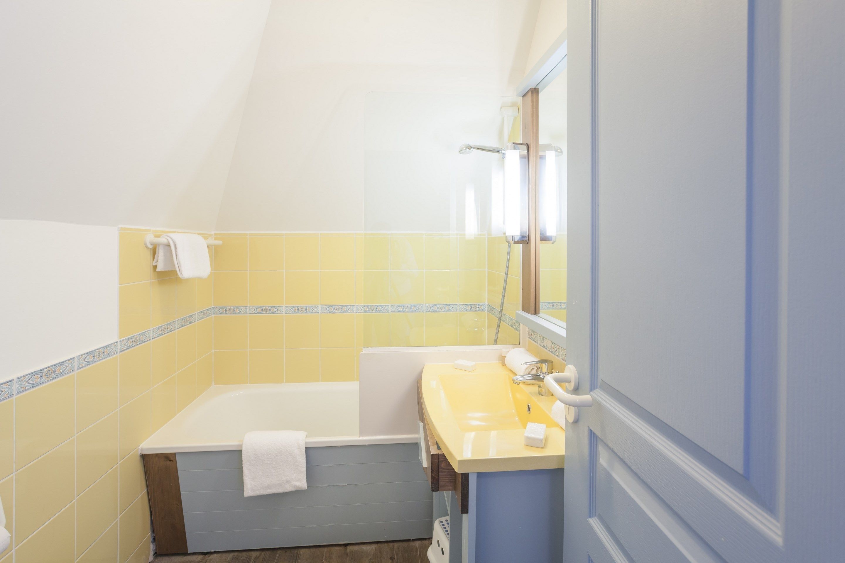 A bathroom with a bathtub, a sink, and a mirror.