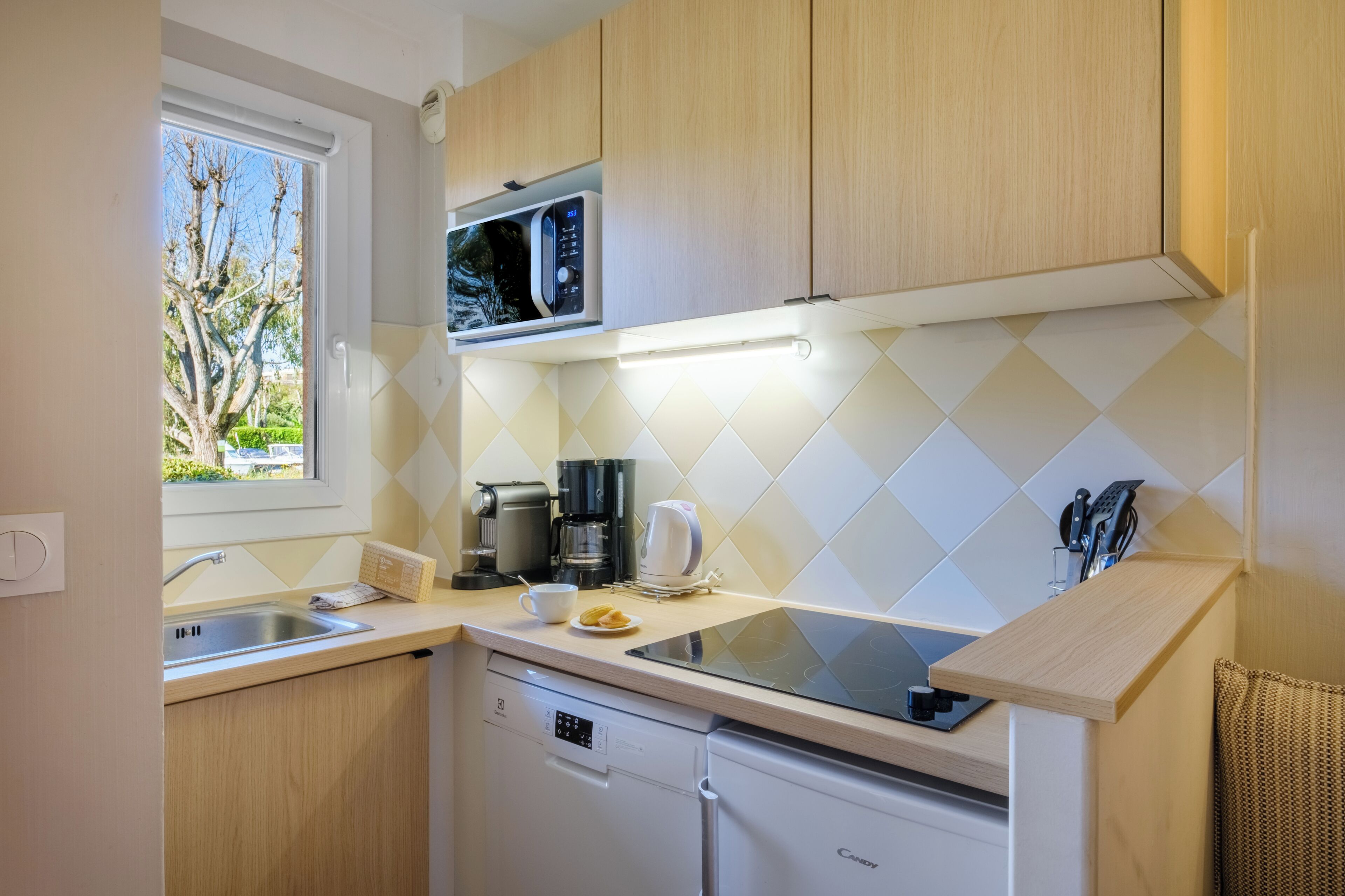 A modern kitchen with a microwave, coffee maker, and dishwasher.