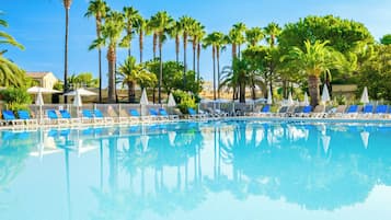 Una piscina al aire libre de temporada, sombrillas