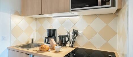 A modern kitchen with a microwave, coffee maker, and a dishwasher.