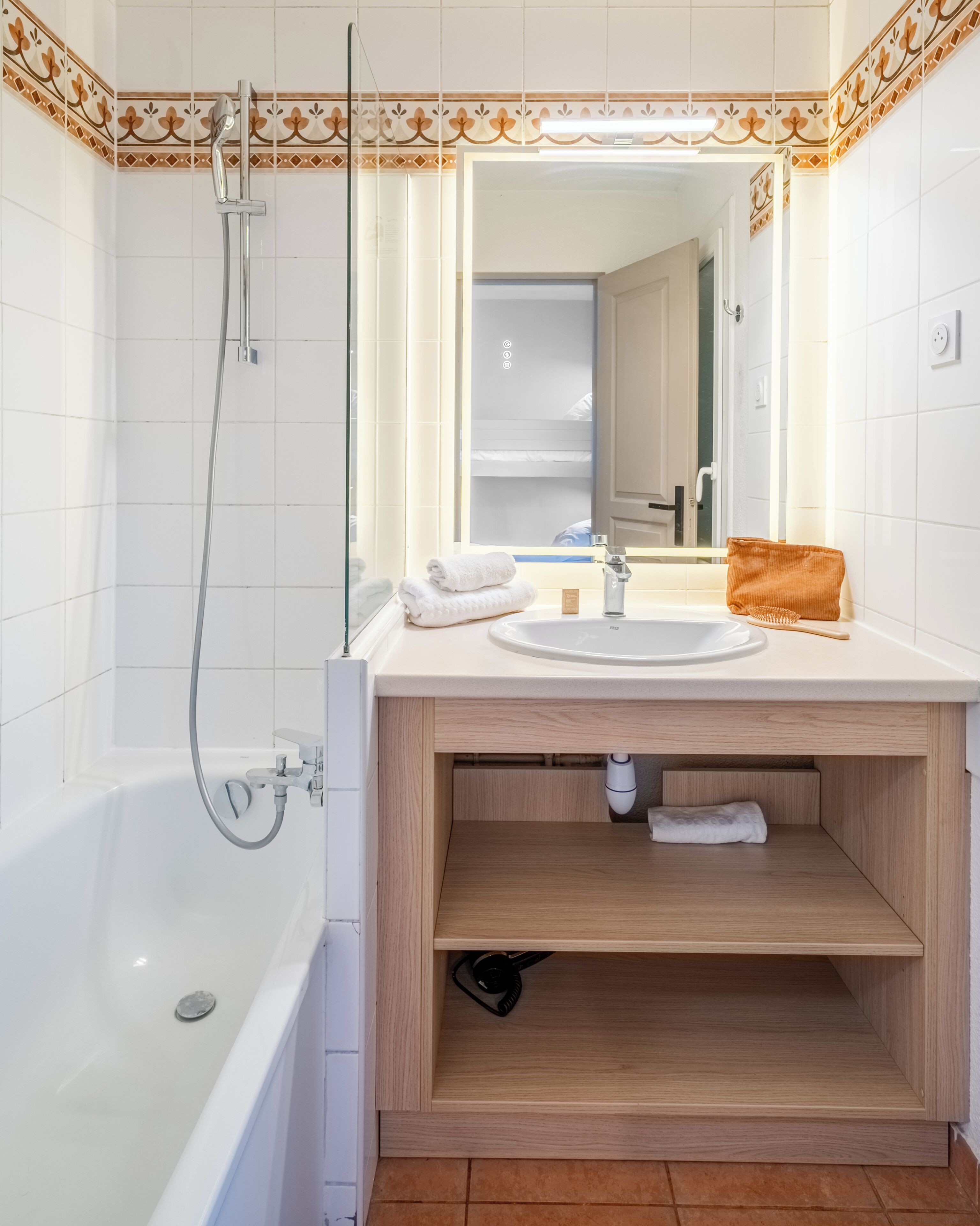 Un baño moderno con bañera, lavamanos, espejo y ducha.