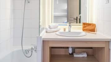 A modern bathroom with a bathtub, a sink, a mirror, and a shower.