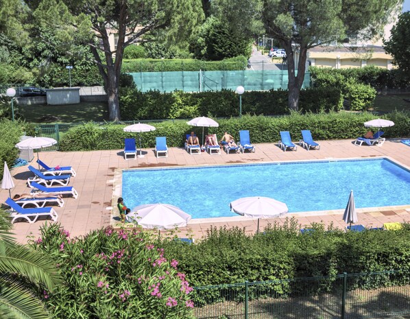 Una piscina al aire libre de temporada, tumbonas