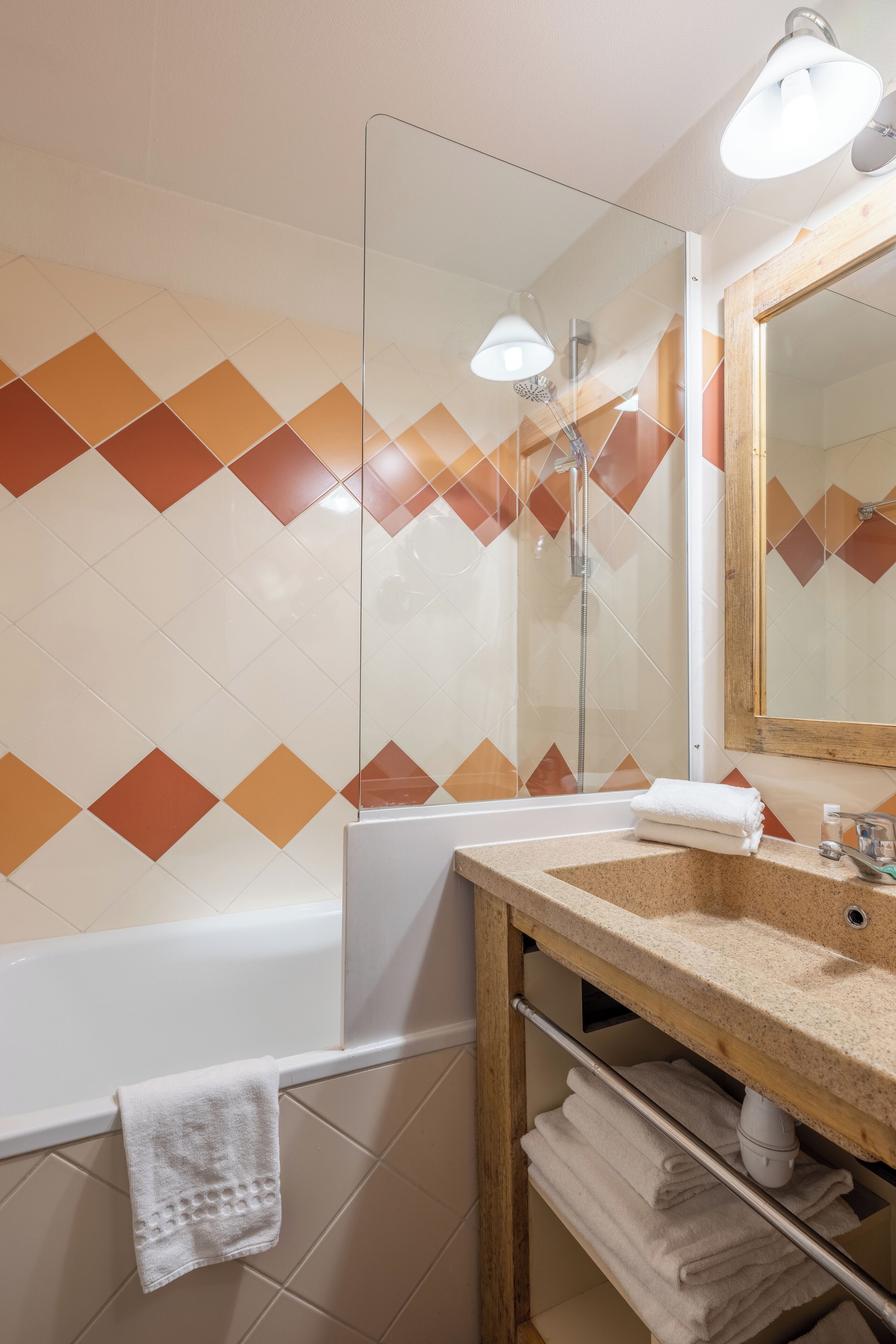 A bathroom with a bathtub, a sink, a mirror, and a towel rack.
