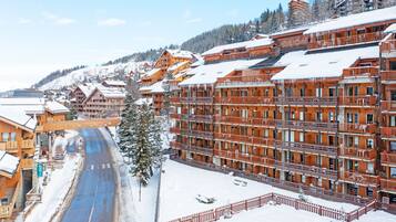 A snow-covered town with wooden buildings and a clear road.