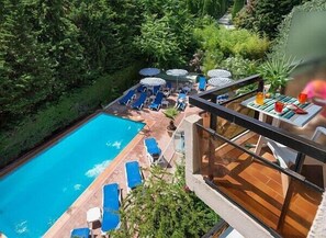 Una piscina al aire libre de temporada, sombrillas, tumbonas