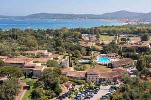 Un complejo turístico frente al mar con villas, piscina y vistas al océano.