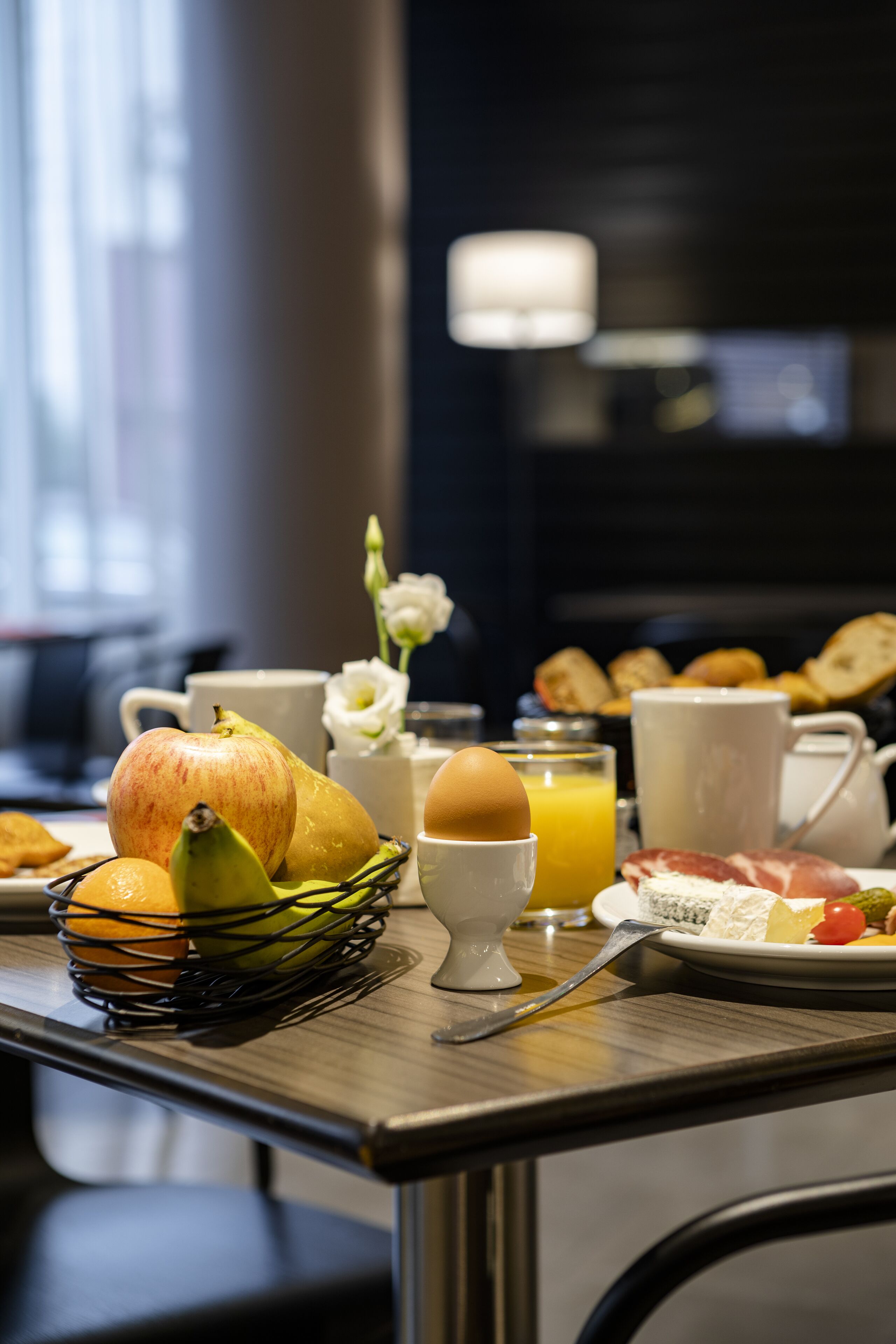 Una tavola imbandita per la colazione con frutta, uova e bevande.