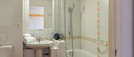 A bathroom with a sink, mirror, and shower.
